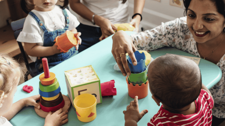 Erzieherin mit Kindern spielend am Tisch